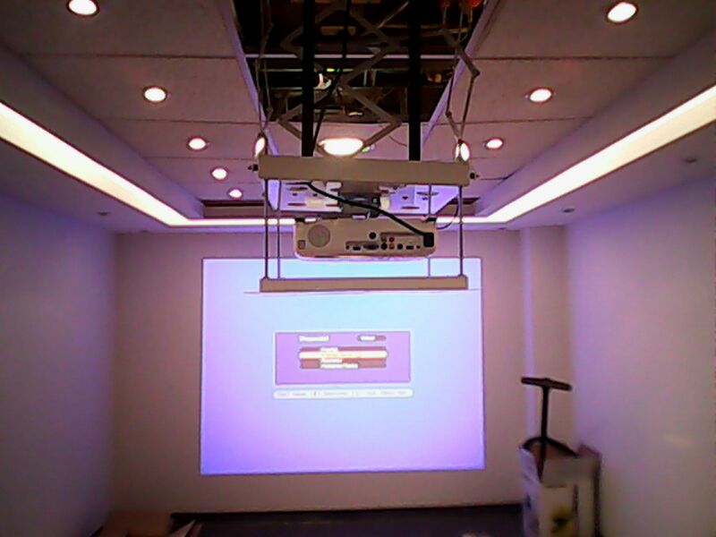 Proyector instalado en techo con soporte eléctrico
